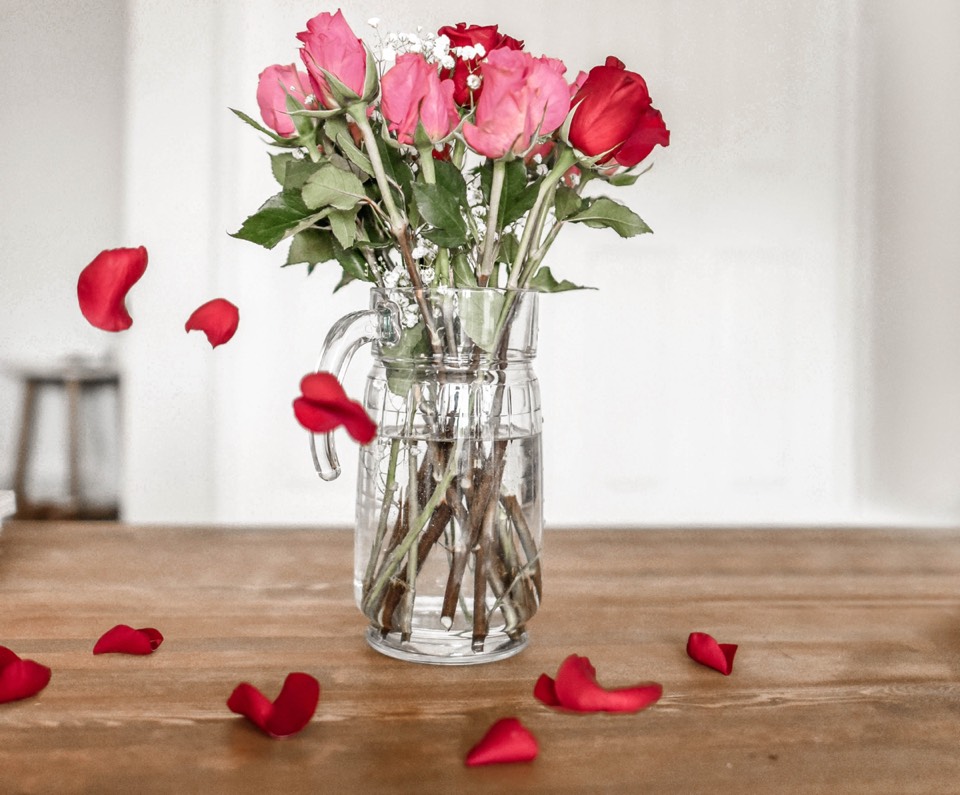 roses in vase with dropping petals